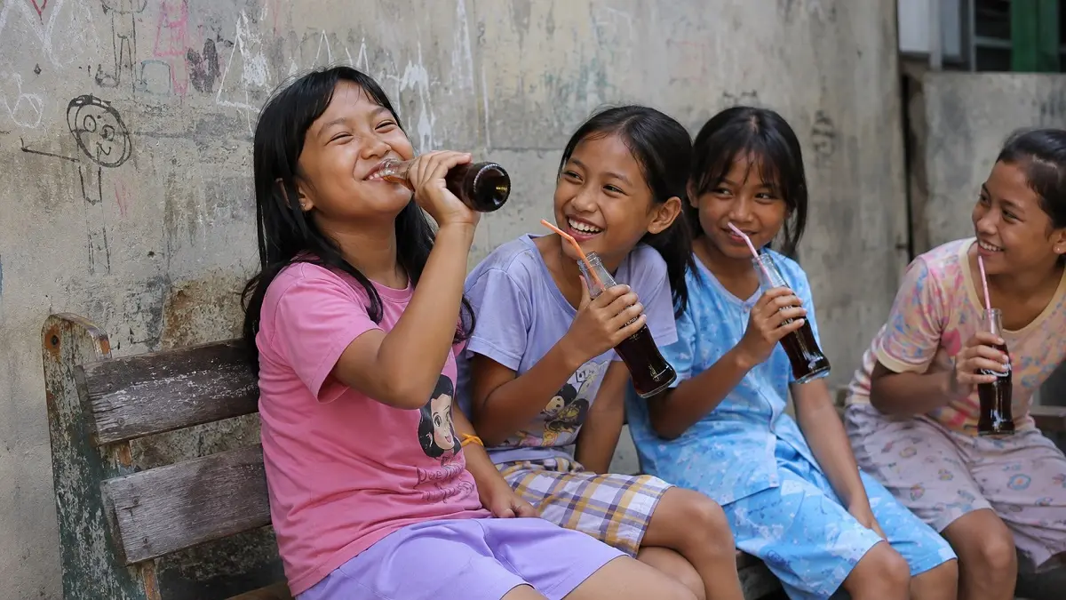 Ilustrasi anak-anak sedang menikmati minuman bersoda. (ChatGPT)