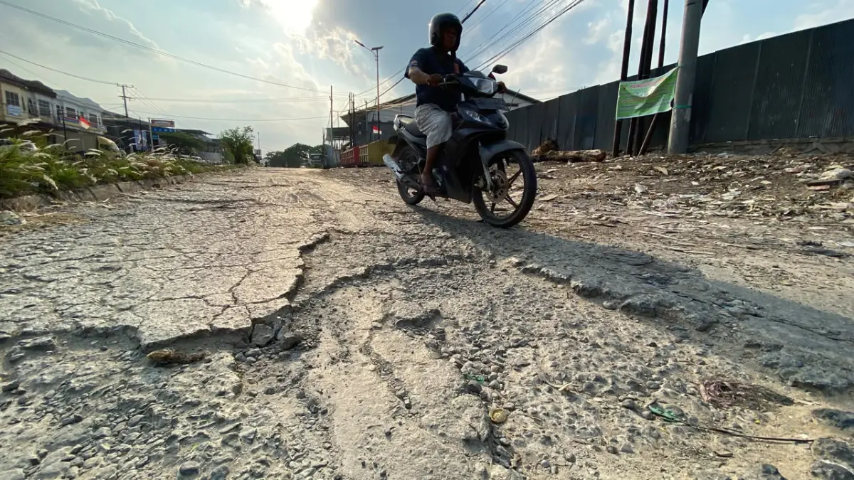 BUTUH ANGGARAN: Kerusakan badan jalan di kawasan Ring Road Samarinda. Tampak aspal terkelupas dan permukaan yang bergelombang. Penanganan komprehensif pada jalur ini terkendala oleh belum terbangunnya drainase utama serta proses pembebasan lahan warga. (RAMA SIHOTANG/KALTIM POST)
