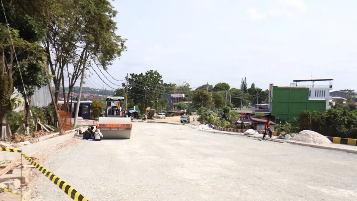 RAMPUNG: Pekerja dan alat berat melakukan pelapisan aspal di Jalan Syarifuddin Yoes, Balikpapan. Perbaikan jalan longsor yang menyerap anggaran BTT Rp 9,8 miliar ini telah rampung dipasang 100 bore pile dan siap beroperasi penuh. (ANGGI PRADITHA/KP)