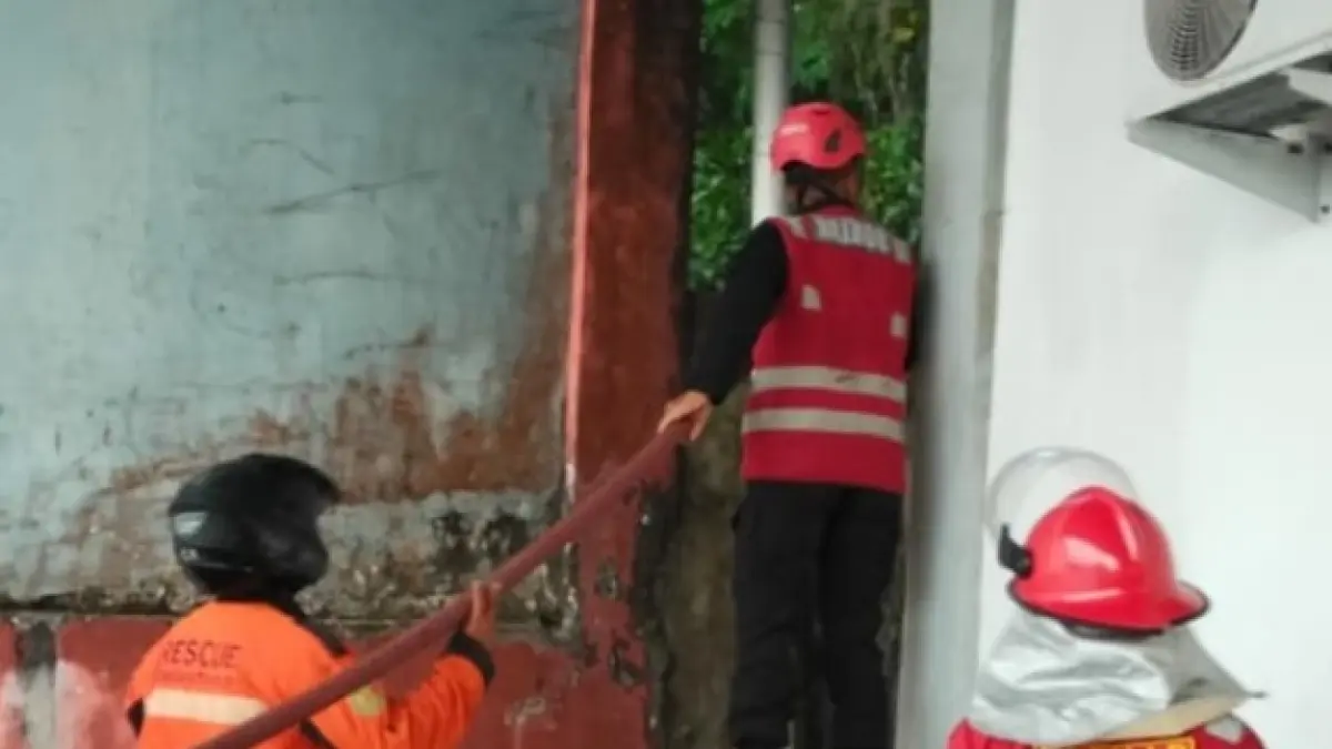 PEMADAMAN: Petugas berupaya memadamkan kebakaran di belakang rumah warga agar api tak merembet.