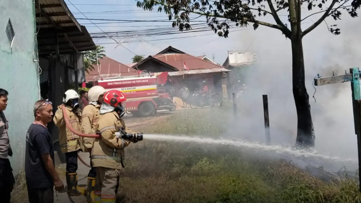 PADAMKAN API:&nbsp;Petugas Disdamkartan Bontang menjinakkan si jago merah yang berkobar di lahan Jalan HM Ardan. (FOTO:ADIEL KUNDHARA/KP)