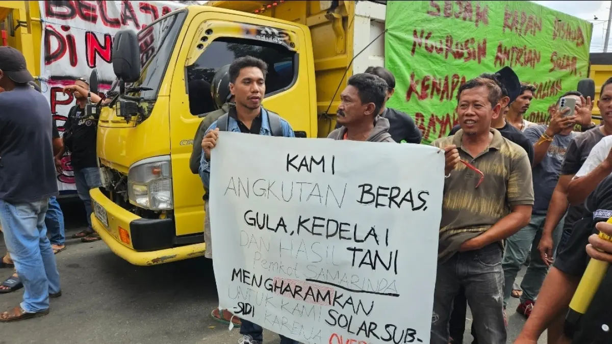 MENOLAK: Sejumlah sopir truk membawa poster berisi tuntutan saat menggelar aksi menolak pembatasan kupon subsidi di depan Balai Kota Samarinda, Senin (24/8).