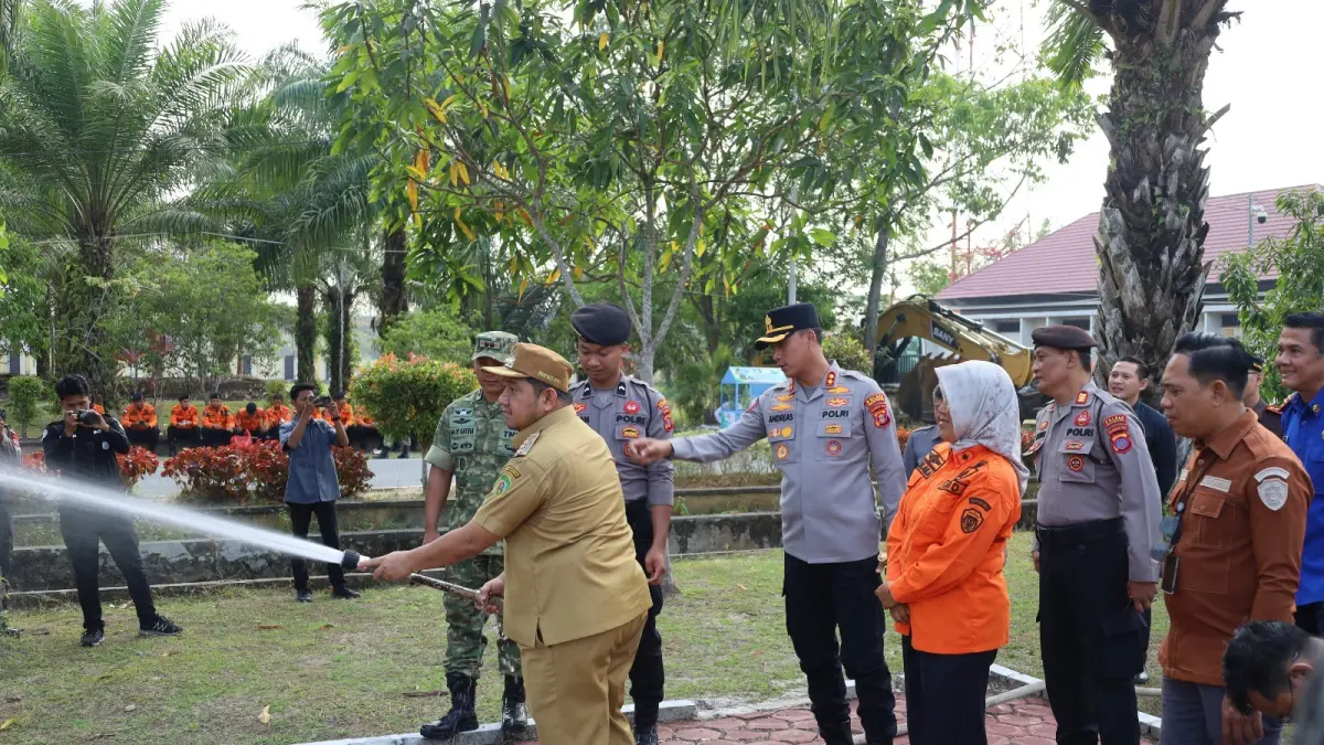 SIMBOLIS: Bupati PPU, Mudyat Noor, secara simbolis menyemprotkan air dari selang menandai kesiapan antisipasi karhutla.(Dok.Humas Polres PPU)