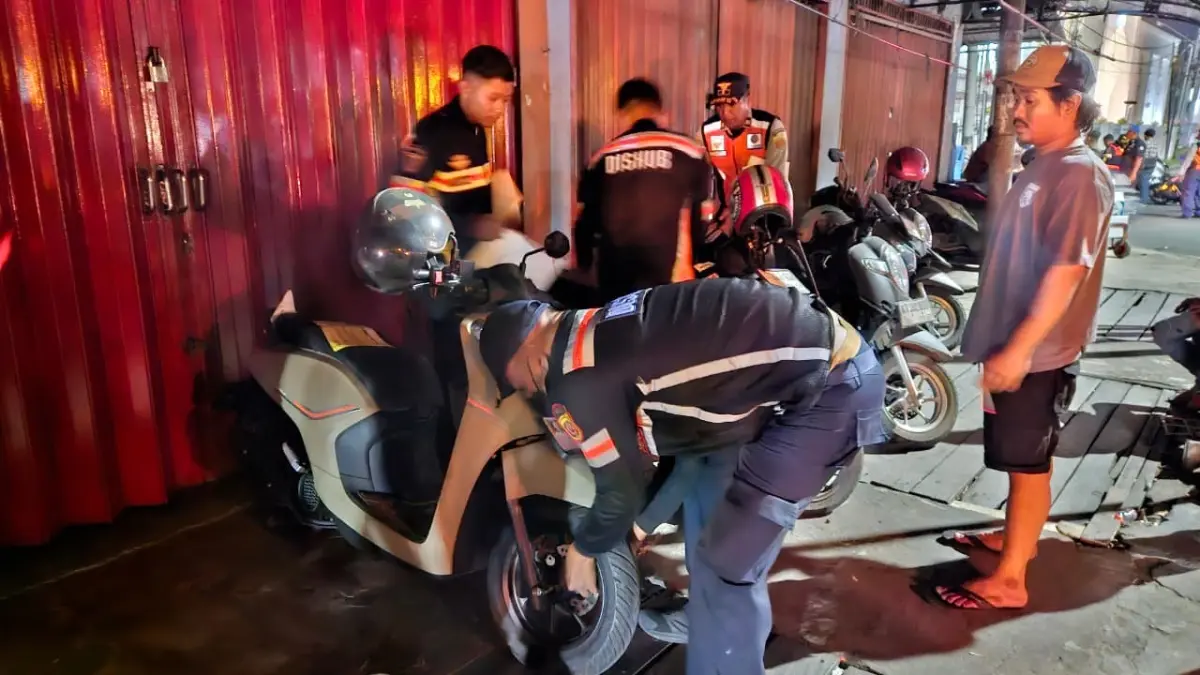 Petugas Dishub Samarinda menggembosi kendaraan yang parkir sembarangan di kawasan Teras Samarinda Tahap II, Senin (1/9) malam. (HAFIZ/KALTIM POST)