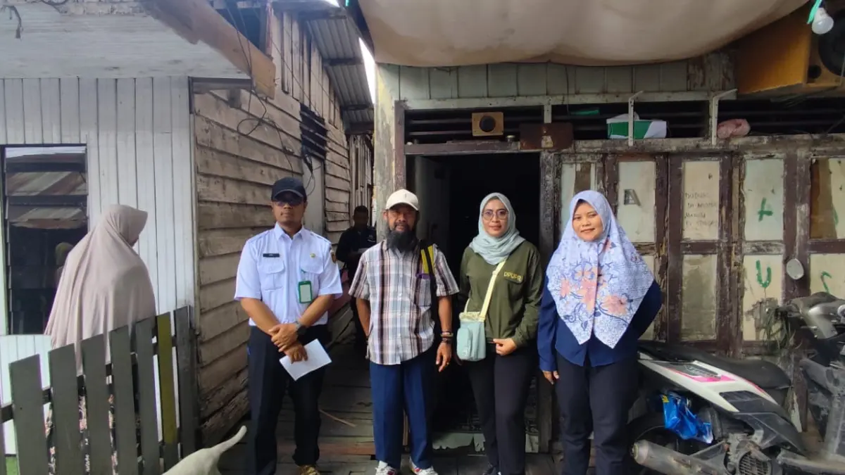 PENDATAAN: Solikin (kedua kiri) bersama tim kelurahan dan bidang Pertanahan DPUPR  Samarinda, berdiri di depan rumah salah satu warga yang terdampak rencana normalisasi SKM tahun ini, di Kelurahan Sidomulyo, Kecamatan Samarinda Ilir, Rabu (2/9) (DENNY SAPUTRA/KP)
