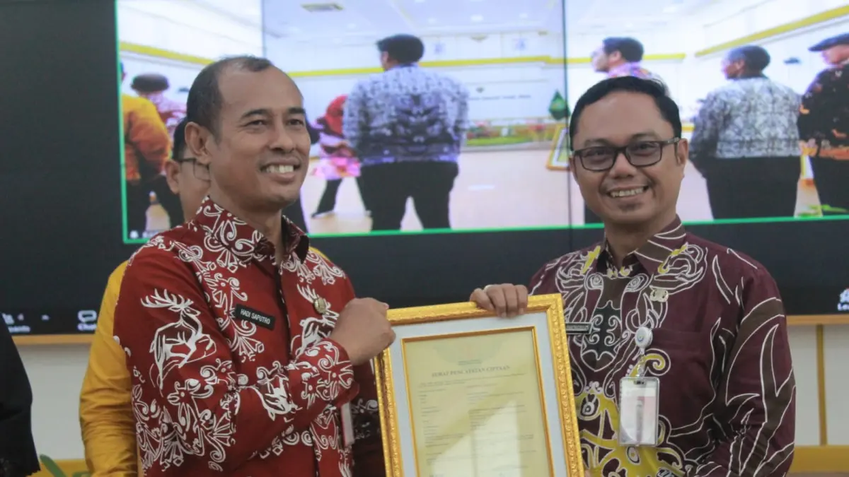 KEKAYAAN INTELEKTUAL: Hadi Saputro (kiri) menyerahkan salah satu sertifikat HAKI ciptaan lagu jingle Gerbang Nusantara yang diwakilkan Plt Bapelitbang PPU Ade Embongbulan, Kamis (3/9/2026).
