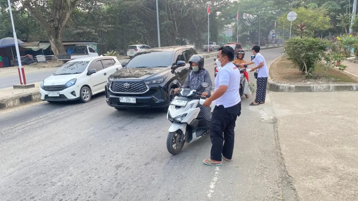 Pembagian masker kepada masyarakat oleh kader Partai Gerindra Kubar di tengah kabut asap dampak karhutla.