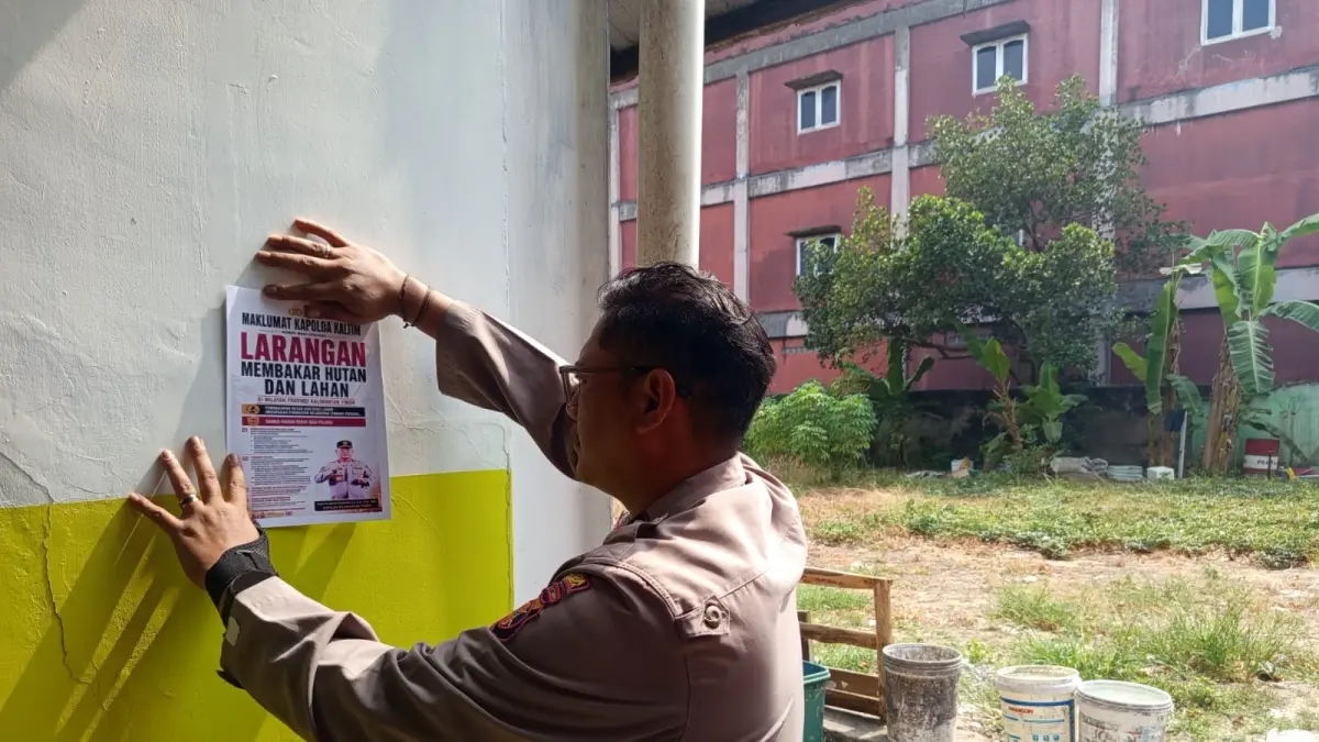 INGATKAN: Personel Sat Binmas Polresta Samarinda memasang Maklumat Kapolda Kaltim tentang larangan membakar hutan dan lahan di salah satu titik strategis di Samarinda. (IST)