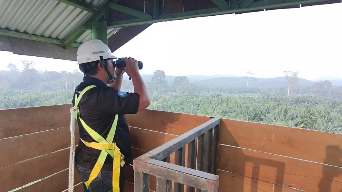 PANTAU API: Jurnalis Kaltim Post, Nugroho Pandu Cahyo ikut memantau kondisi kebun PT Yudha Wahana Abadi dari menara pantau, Kamis (3/9). Di sini petugas bisa melihat 360 derajat dengan jangkauan hingga 600 hektare.