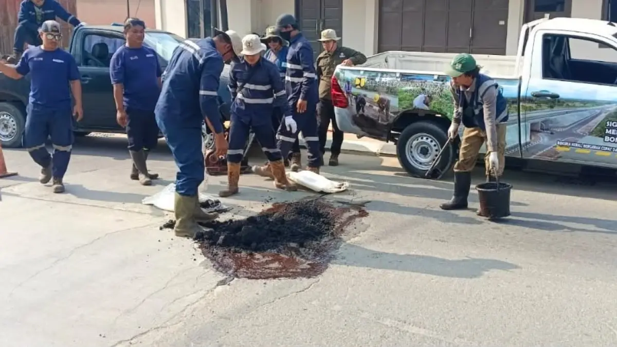 Tim BRC Dinas PUPRK Bontang menambal lubang di Jalan HM Ardan, sekitar Kantor Dinas Perpustakaan dan Kearsipan Kota Bontang, Senin (7/9/2026). (ADIEL KUNDHARA/KALTIM POST)