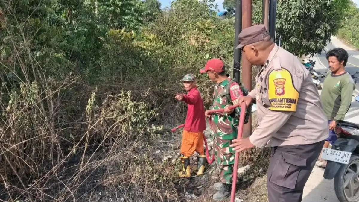 KEBAKARAN: Asap yang timbul diduga dari kebakaran lahan dipadamkan petugas gabungan dan warga setempat.