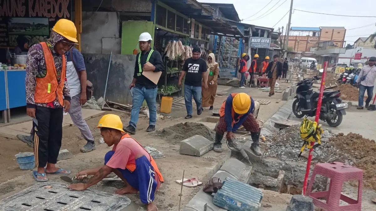 DIKEBUT: Kontraktor saat ini masih melakukan pengerjaan trotoar di Jalan HM Ardans, namun ini tidak mencakup seluruh panjang di ruas jalan tersebut. ADIEL KUNDHARA/KP