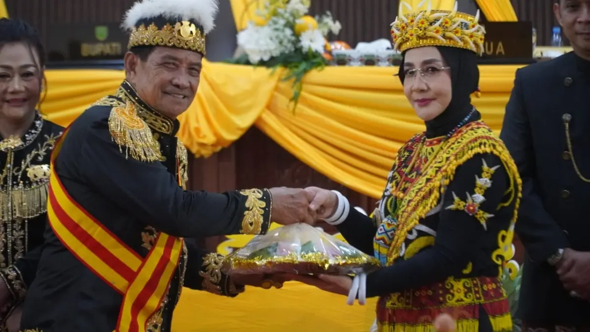 Sri Juniarsih (kanan) memberikan potongan tumpeng kepada Sultan Sambaliung Datu Amir.