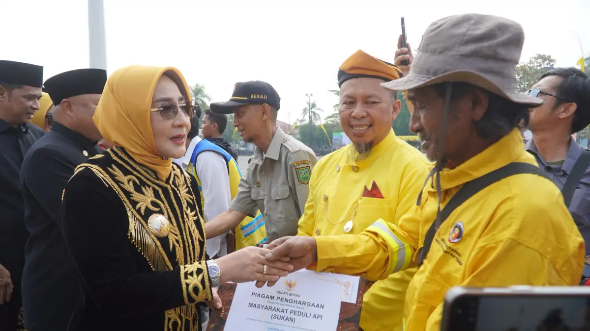 APRESIASI: Bupati Berau Sri Juniarsih Mas menyerahkan apresiasi dari pemerintah daerah kepada masyarakat yang turut terlibat dalam penanganan kebakaran di Lapangan Pemuda GOR, Selasa (15/9).