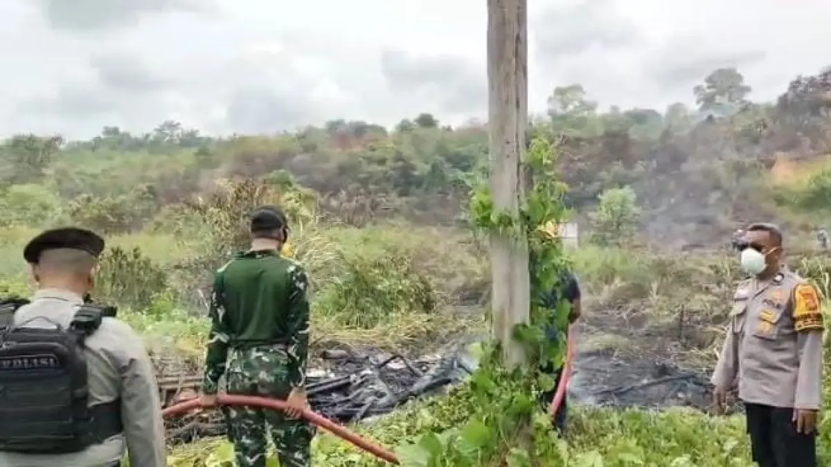 TERBAKAR: Kobaran api di lahan kosong berusaha dipadamkan agar tak menyulut rumah warga.