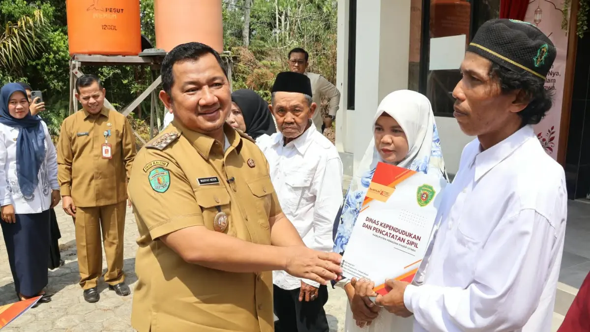 BERKAS RESMI: Bupati PPU, Mudyat Noor, menyerahkan berkas salah satu perwakilan dari 15 pasangan di Kantor KUA Kecamatan Penajam, Senin (21/9).