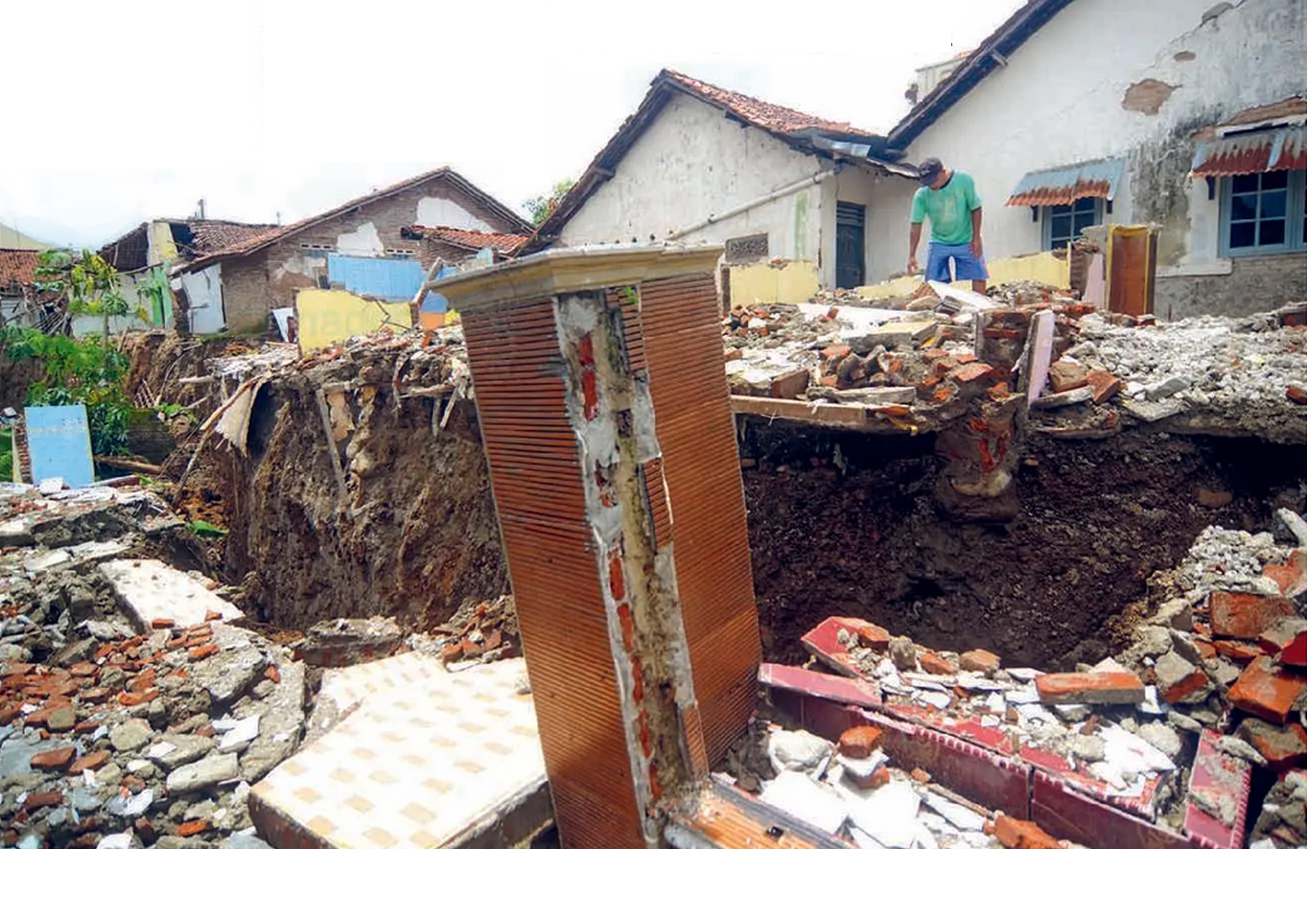 Warga berdiri di reruntuhan rumah terdampak longsor di Desa Kajen, Kabupaten Tegal, Jawa Tengah, kemarin (11/2).