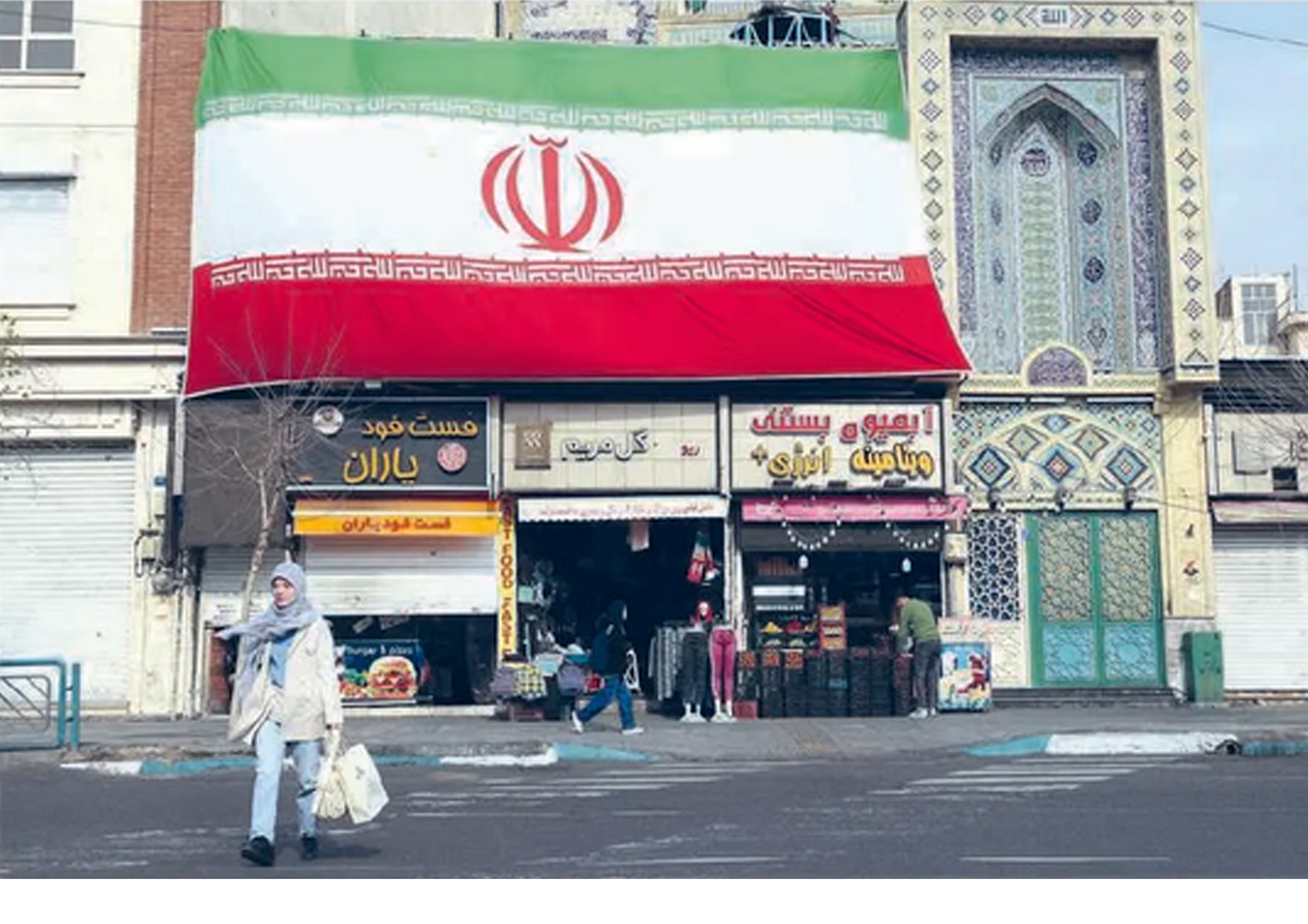 TERKENA IMBAS: Seorang perempuan berjalan di dekat pertokoan di Teheran, Iran. Protes nasional dan situasi politik berdampak pada ekonomi.