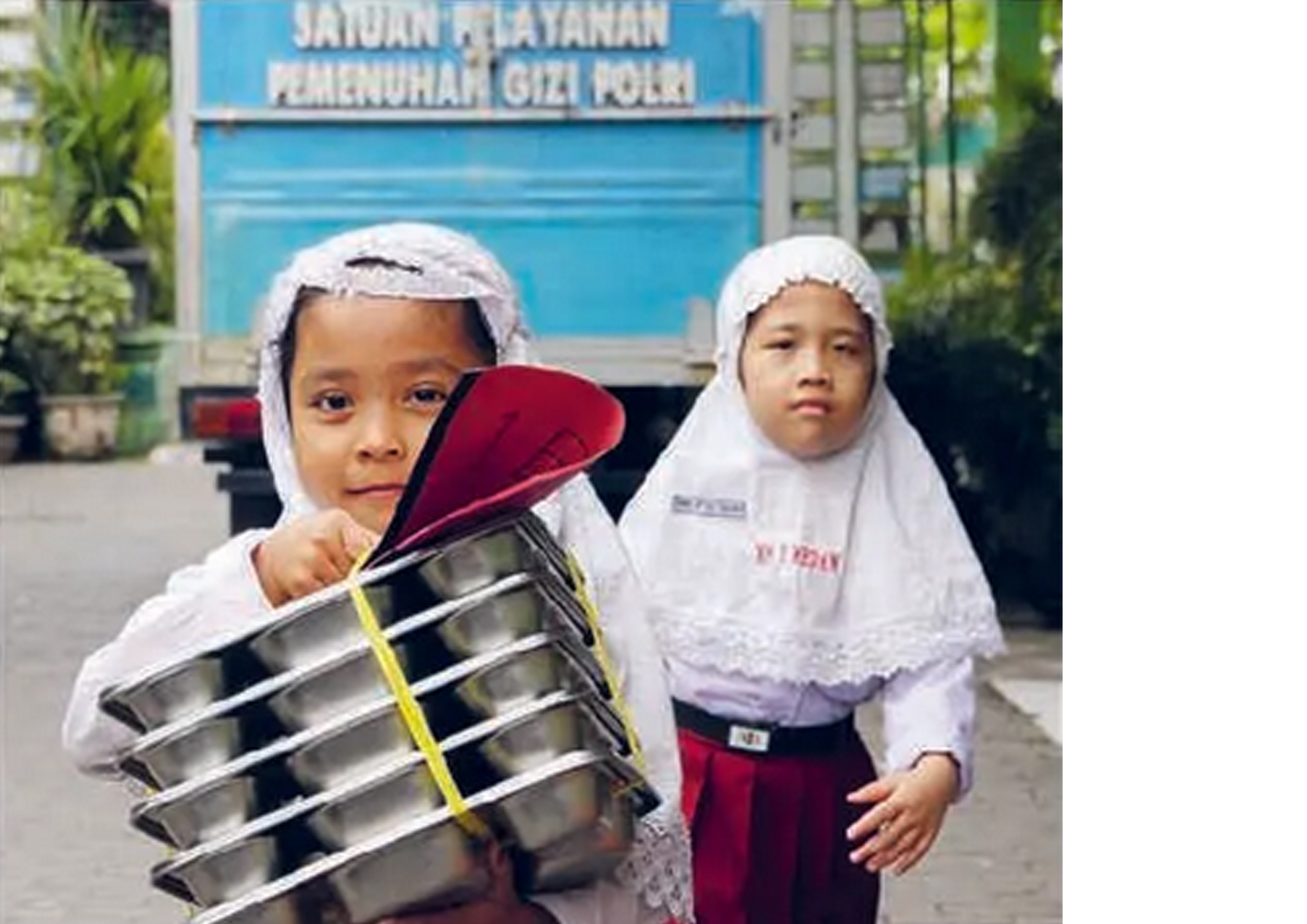 Siswa membawa MBG di MI Negeri Medan, Sumut. Selama Ramadan, BGN mengubah skema distribusi MBG.