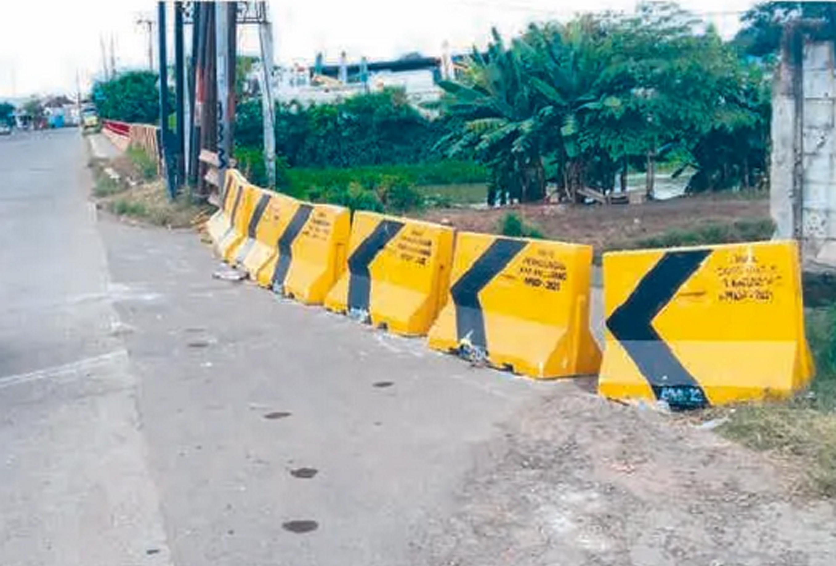 LOKASI KEJADIAN: Turunan yang memicu truk trailer terguling hingga menimpa mobil dan menewaskan tiga orang di Jalan Raya Tanjungpura, Karawang, Jawa Barat, ditutup.