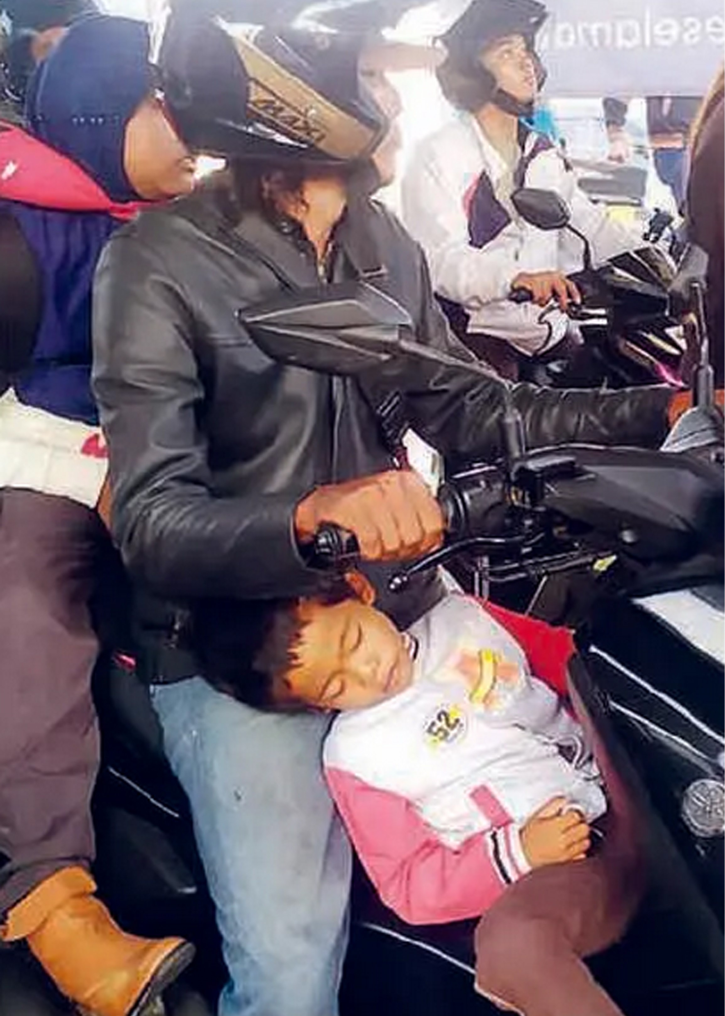 DEMI BISA PULANG KAMPUNG: Seorang anak tertidur di motor yang sedang antre di Pelabuhan Gilimanuk, Bali, kemarin (17/3).