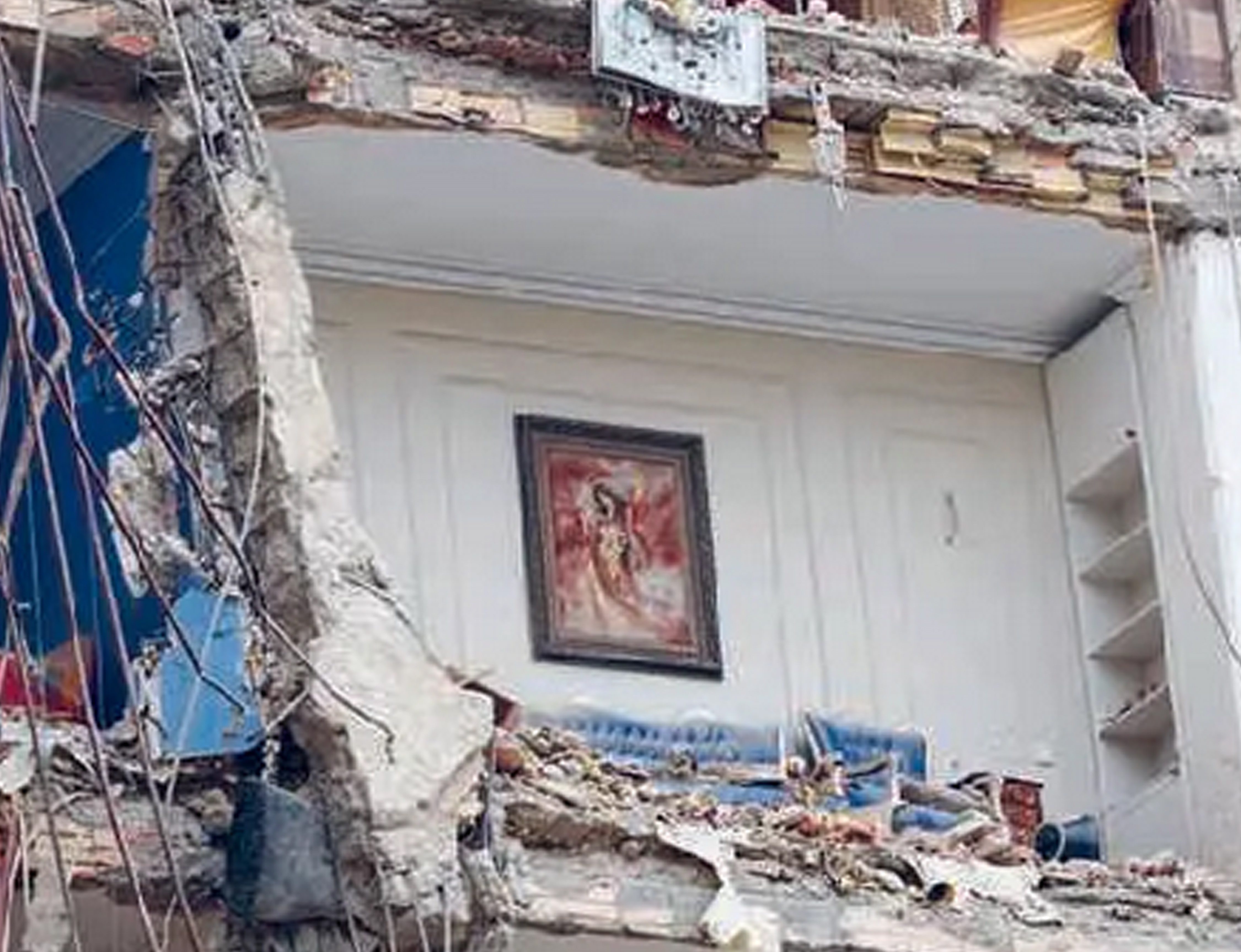 Sebuah lukisan menggantung di tembok tempat tinggal di Teheran yang terkena serangan Israel-AS (23/3).