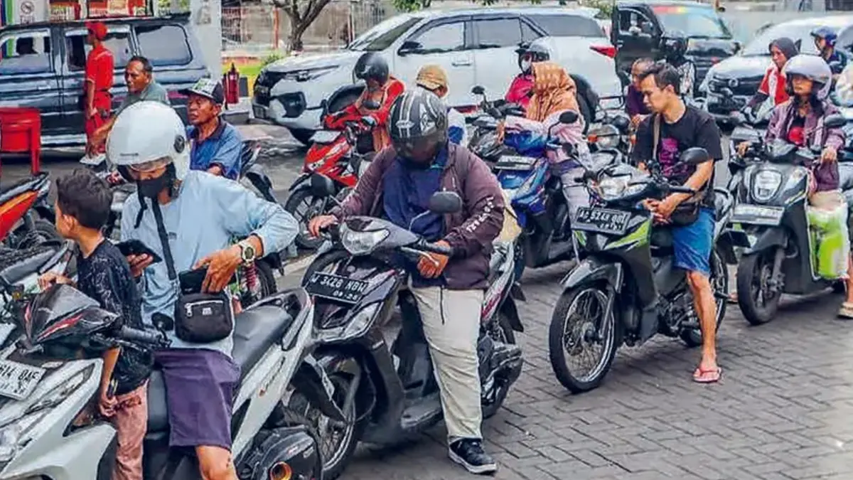 PANIC BUYING: Pemotor antre membeli bensin di SPBU Kebonsari, Surabaya, kemarin (31/3). Antrean tersebut memanjang hingga ke luar area SPBU.