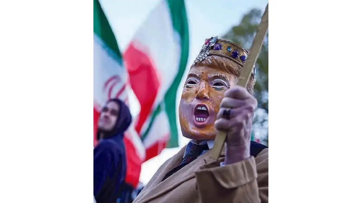 UNJUK RASA: Seorang demonstran mengenakan topeng bergambar Donald Trump di dekat Gedung Putih, Washington, untuk menentang invasi AS terhadap Iran, Selasa (7/4). (BRENDAN SMIALOWSKI/AFP)