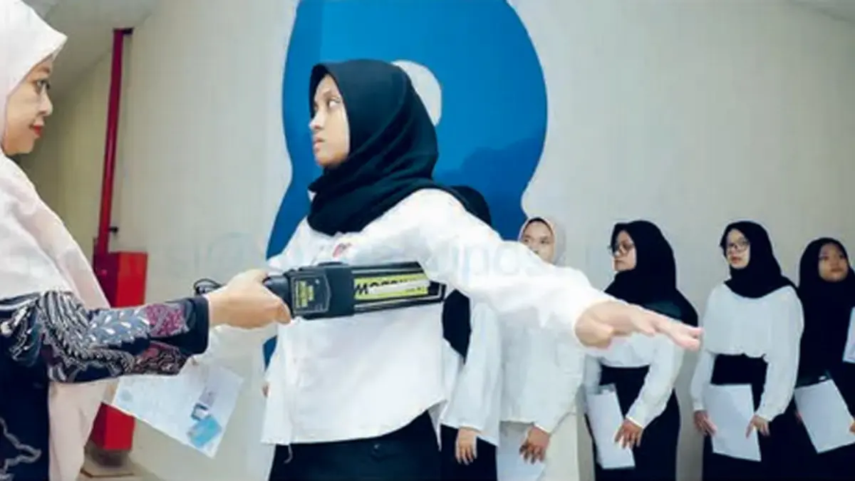 PENGAWASAN KETAT: Pemeriksaan menggunakan metal detector sebelum peserta masuk ruang UTBK di Kampus C Universitas Airlangga, Surabaya, kemarin (21/4).