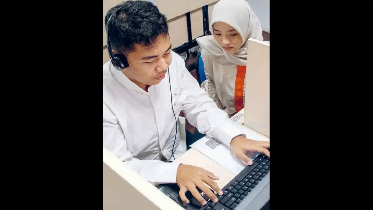 TAK INTERVENSI: Nabili Iqbal Setiya Aji (kiri), penyandang disabilitas peserta UTBK di Unesa, mendengarkan soal lewat headset kemarin (23/4).
(UNESA)
