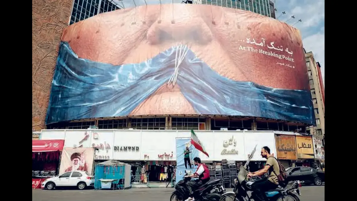 SEMANGAT PERLAWANAN: Sejumlah pemakai jalan melewati billboard anti-AS yang merujuk ke Presiden Donald Trump di Alun-Alun Valiasr, Teheran (2/5).