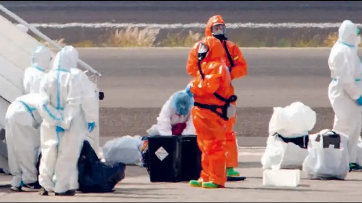 SANGAT HATI-HATI: Warga Spanyol yang dievakuasi dari Kapal MV Hondius mengenakan baju pelindung putih berjalan menuju pesawat Airbus A310 di Bandara Tenerife kemarin (10/5). Pesawat tersebut membawa mereka ke Madrid untuk menjalani karantina. (AFP)