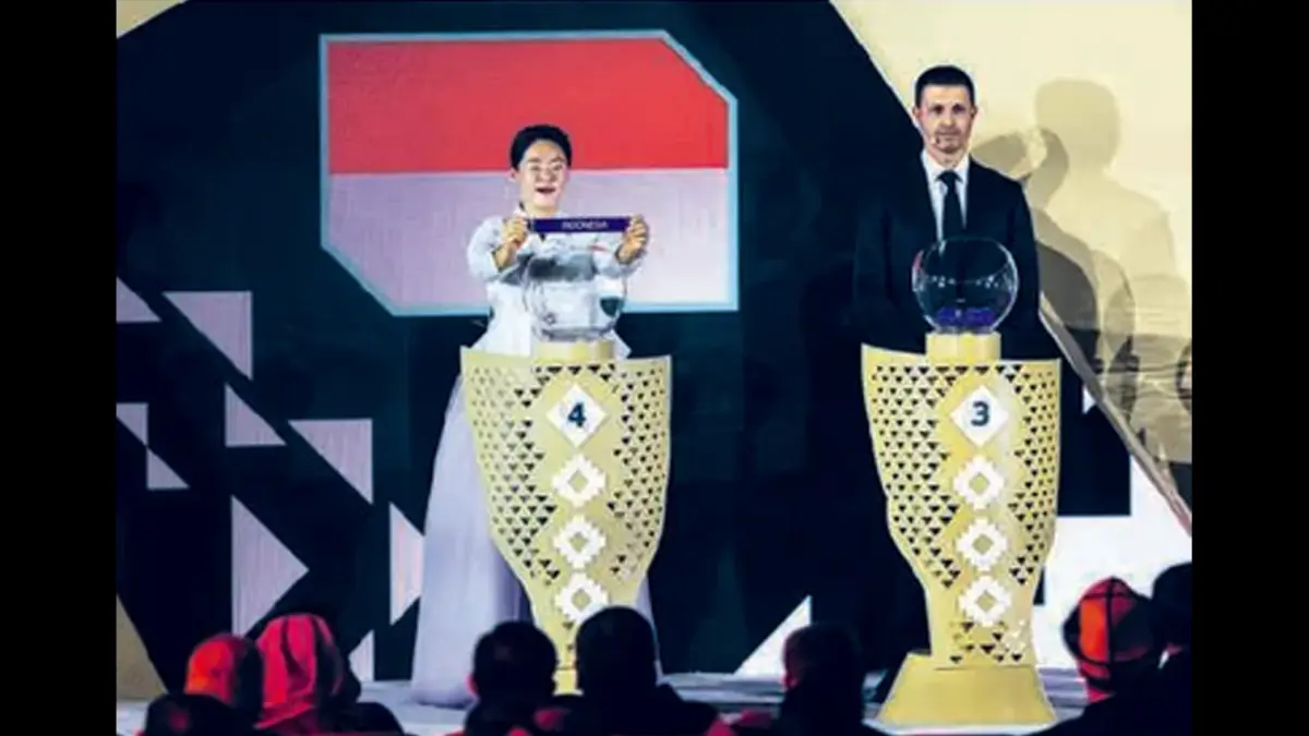 TAK GENTAR: Wasit FIFA asal Korsel Kim Yu-jeong mengambil kertas bertulisan Indonesia saat drawing Piala Asia 2027 di Riyadh, Sabtu (9/5). (AFP PHOTO)
