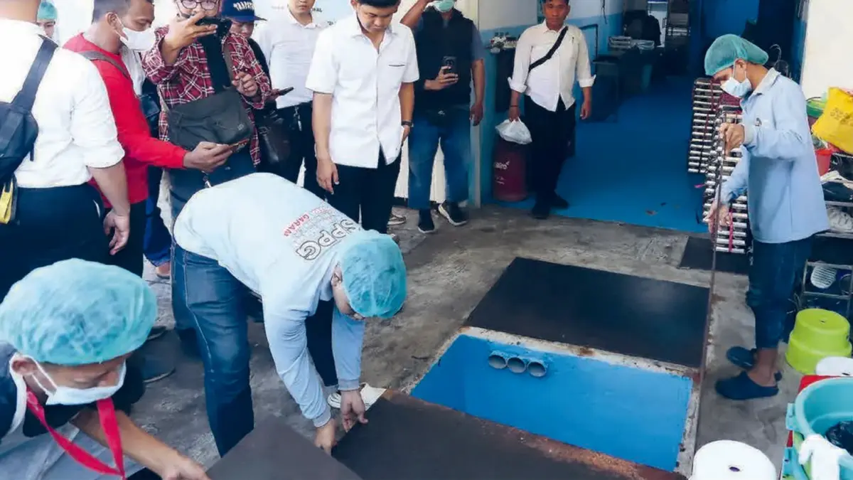 USUT SUMBER KERACUNAN: Petugas Dinas Lingkungan Hidup Kota Surabaya bersama tim Inafis Polrestabes Surabaya mengecek saluran pembuangan air di SPPG Tembok Dukuh kemarin (11/5). Foto: PUGUH SUJATMIKO/JAWA POS