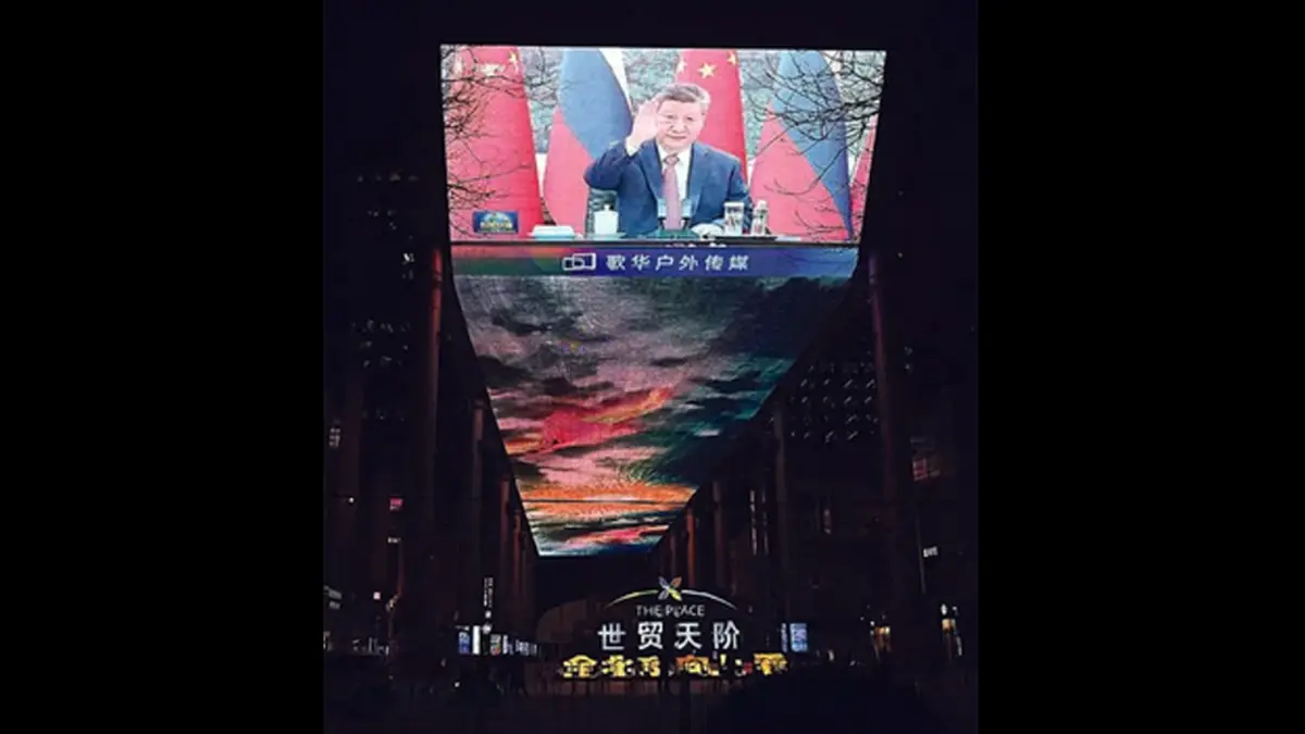 PERKUAT ALIANSI: Xi Jinping menyapa Vladimir Putin saat panggilan video menjelang pertemuan yang ditayangkan di layar besar pusat perbelanjaan di Beijing, Tiongkok.
(Foto: AFP)