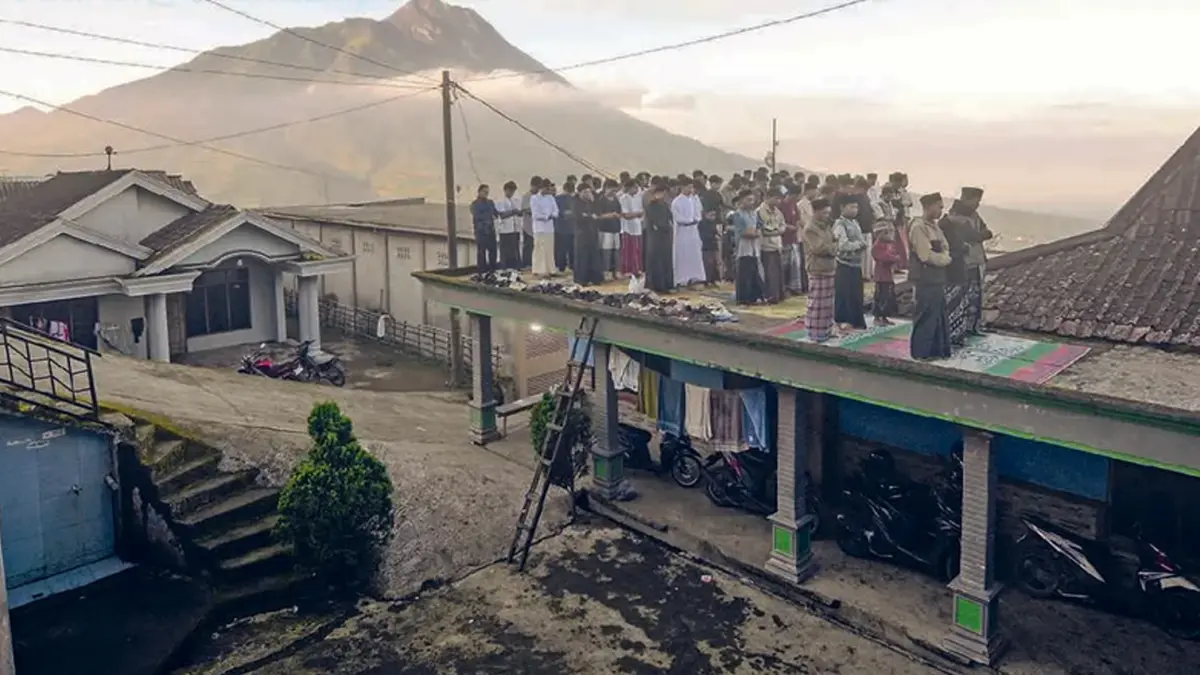 KHUSYUK: Umat Islam di Desa Jrakah, Kabupaten Boyolali, Jawa Tengah, melaksanakan salat Idul Adha dengan latar belakang Gunung Merapi kemarin (27/5). (ALOYSIUS JAROT NUGROHO/ANTARA FOTO)