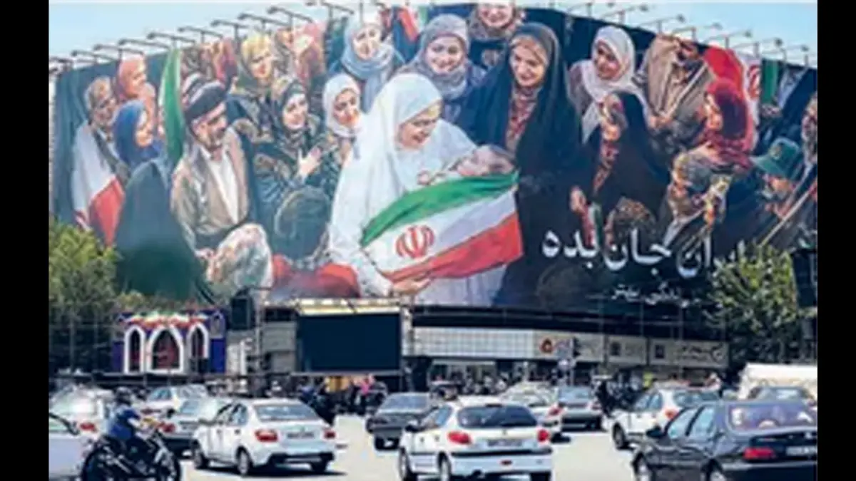 TERUS MELAWAN: Para pemakai jalan melintas di dekat billboard Lapangan Enghelab, Teheran (26/5). Iran menuding AS melanggar gencatan senjata setelah menyerang wilayah selatan mereka. (AFP)
