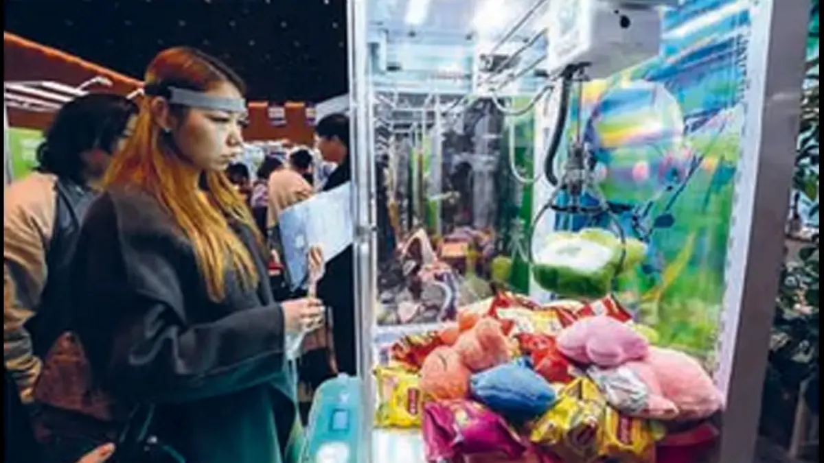 KECANDUAN: Seorang perempuan bermain mesin capit demi mendapatkan boneka di Hongkong. (AFP)