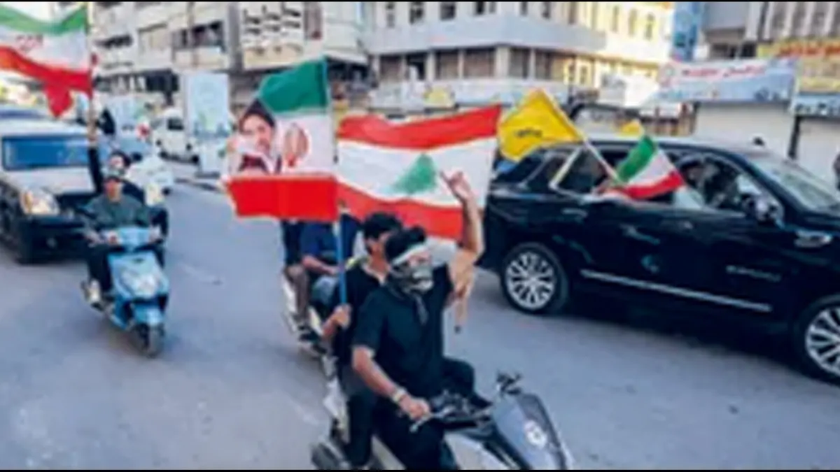TURUT BERGEMBIRA: Anak-anak muda mengibarkan bendera Iraq, Iran, dan Lebanon menyambut tercapainya kesepakatan damai AS dan Iran di Baghdad, Iraq, Senin (15/6).