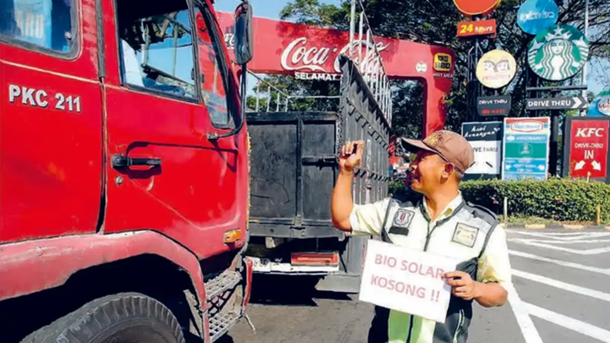 SUPLAI TIDAK LANCAR: Petugas SPBU di Rest Area 754 Tol Surabaya-Sidoarjo menunjukkan tulisan "Bio Solar Kosong" kepada sopir truk yang hendak masuk kemarin (25/6). Di tiap SPBU rest area sepanjang Tol Trans-Jawa, rata-rata ada pengumuman solar kosong. (Foto: ANGGER BONDAN/JAWA POS)