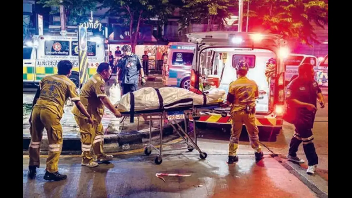 MENINGGAL DI TEMPAT: Petugas mengevakuasi korban kebakaran pub di Bangkok, Thailand, kemarin (13/7). (CHANAKARN LAOSARAKHAM/AFP)