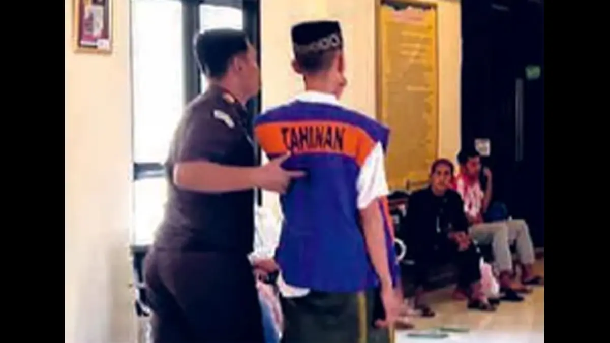 KAWAL KETAT: Satu ABH didampingi petugas Kejari Sampang saat hendak menuju ruang sidang anak di Pengadilan Negeri Sampang, Rabu (22/7). (Foto: UBAIDILLAH RATE/RADAR MADURA GRUP JAWA POS)