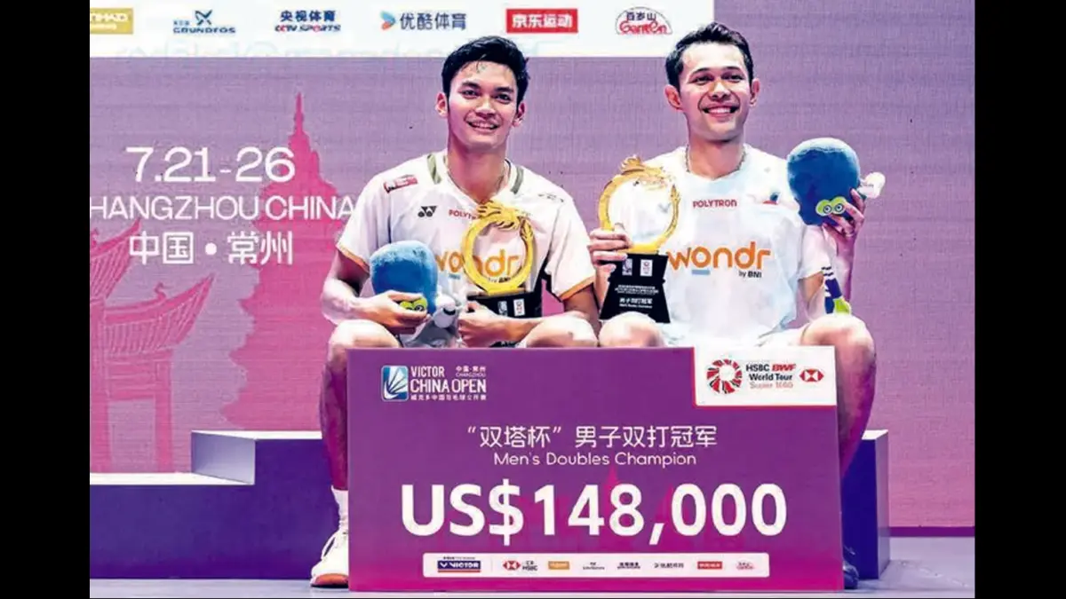 MAKIN SOLID: Fajar Alfian (kanan) dan Muhammad Shohibul Fikri memamerkan trofi juara China Open yang diraihnya tadi malam. (Foto: CN-STR/AFP PHOTO)