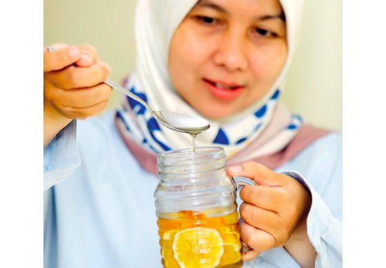 MENYEHATKAN: Andri Prihantini menuangkan satu sendok propolis pada air seduhan lemon. Dia cukup sering mengonsumsi propolis untuk detoksifikasi dan meningkatkan imunitas tubuh. Dari hasil penelitian, propolis mengandung ratusan zat aktif berbagai golongan