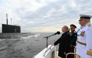 Presiden Rusia Vladimir Putin, Menteri Pertahanan Sergei Shoigu, dan Panglima Angkatan Laut Rusia Nikolai Yevmenov menghadiri parade Hari Angkatan Laut di Saint Petersburg, Rusia, Minggu (25/7/2021). (Sputnik/Aleksey Nikolskyi/Kremlin via REUTERS/rwa/cfo)