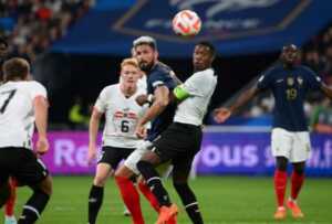 Striker Prancis Olivier Giroud menyundul bola melewati kapten Austria David Alaba dalam laga di Stade de France kemarin (23/9) WIB. (ANNE-CHRISTINE POUJOULAT/AFP )