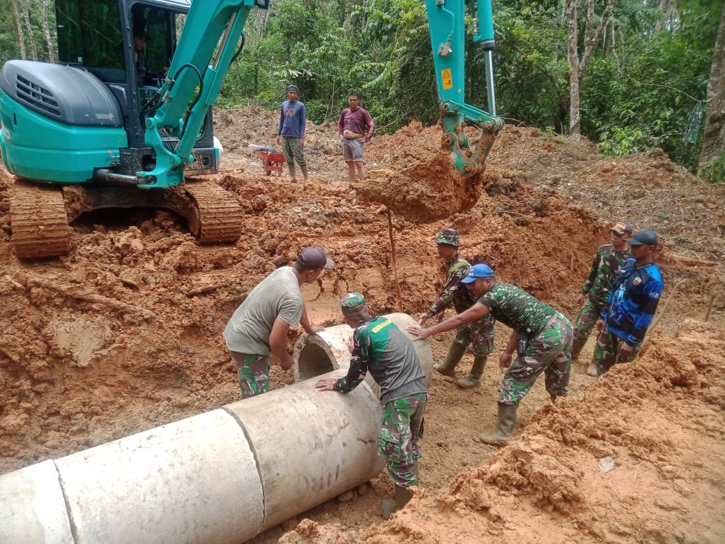 SWADAYA: Tim Satgas TMMD bahu-membahu mengatur posisi polongan di lokasi pembangunan jalan baru Nagari TBA, Sumpurkudus,  kemarin.(DOK KODIM 0310/SSD FOR PADEK)