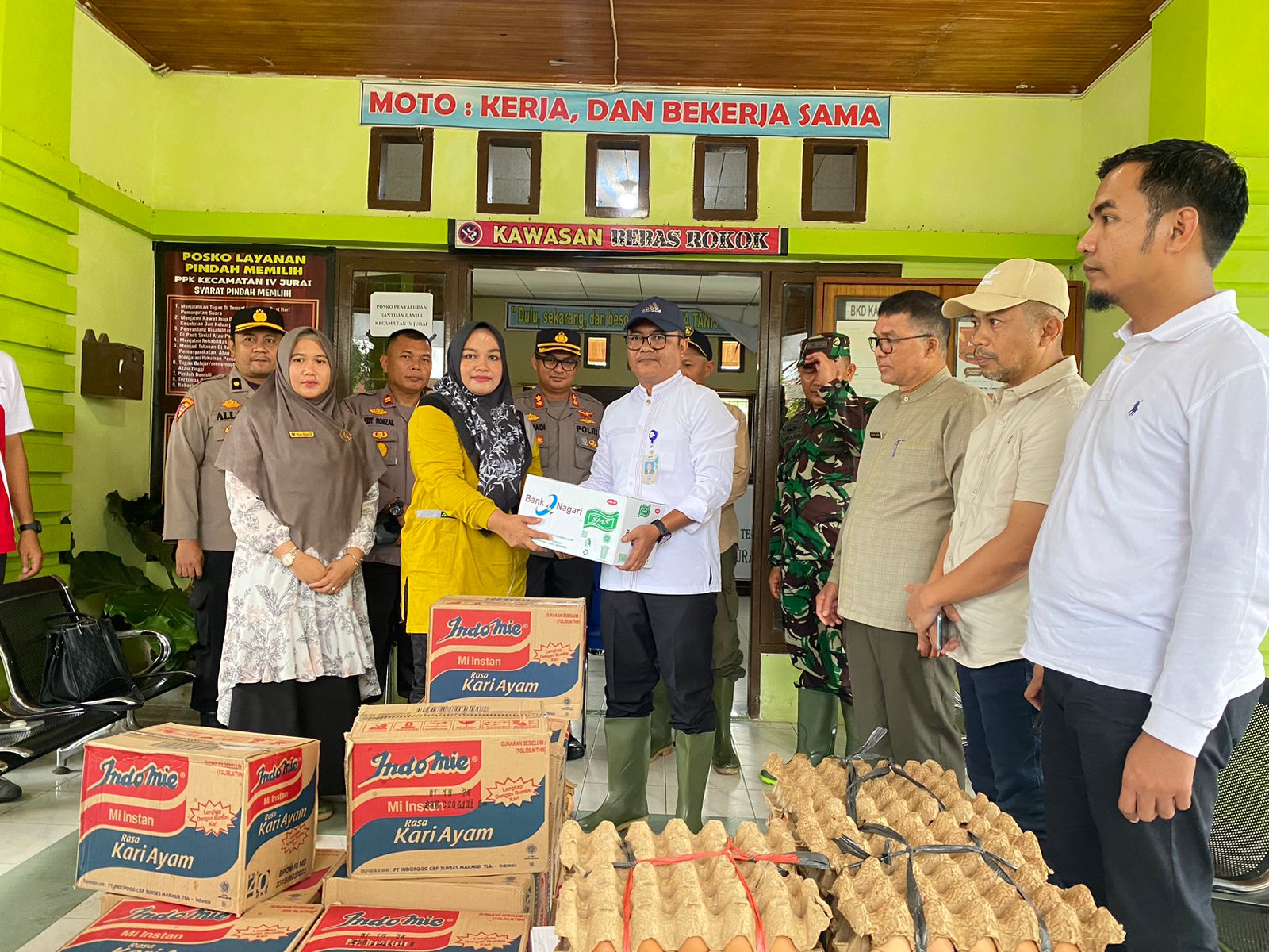 Pemimpin Cabang Bank Nagari Painan Helfiyanrika saat menyerahkan bantuan bagi korban banjir di IV Jurai Pessel. (Foto: Humas Bank Nagari)