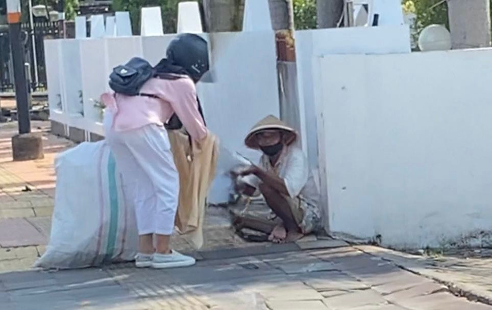 Pengemis di pinggir jalan mendapatkan sumbangan