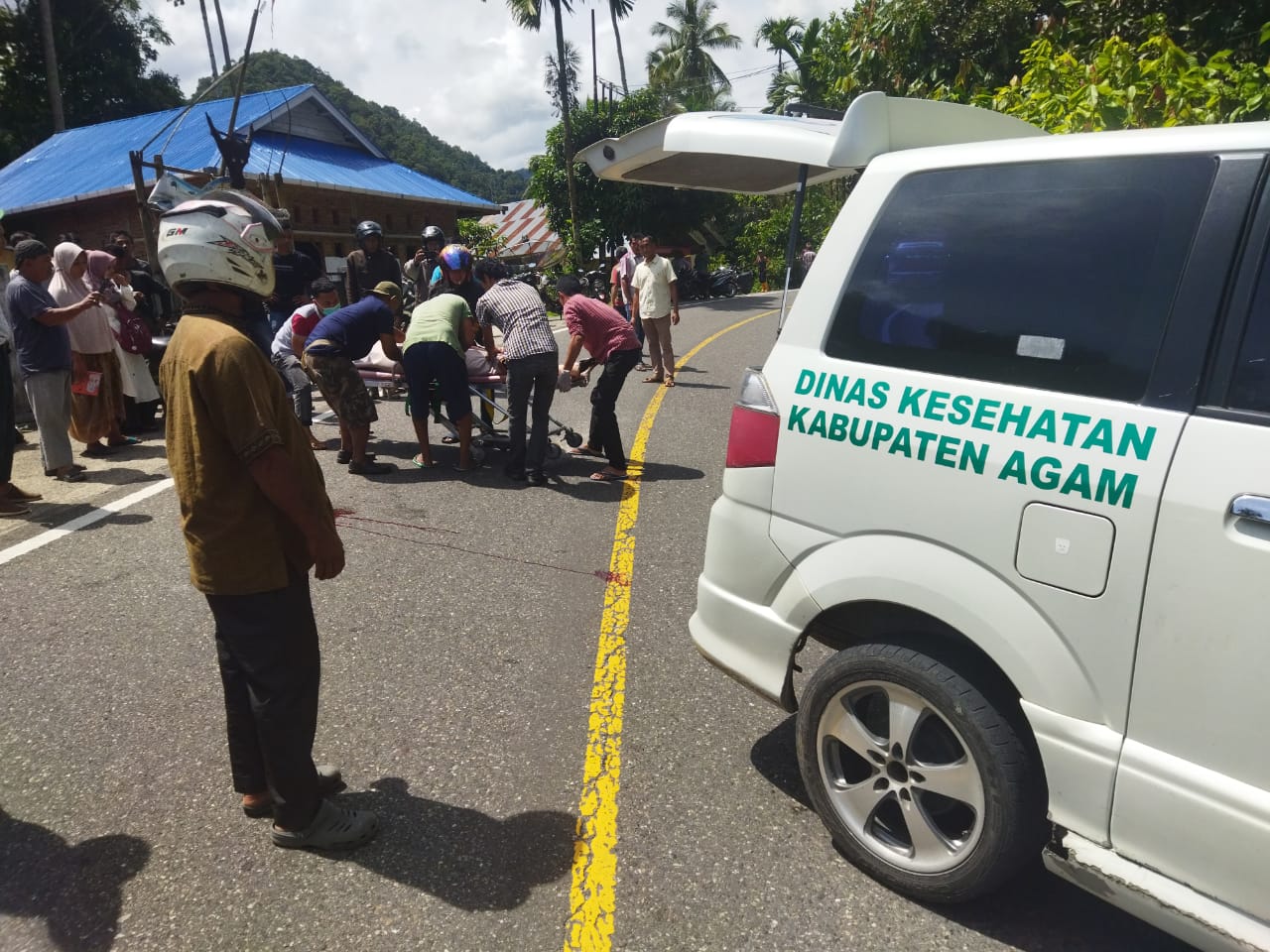 NAHAS: Warga beserta pengguna jalan saat mengevakuasi korban kecelakaan di Jalan Raya Bukittinggi-Pasaman, persisnya di Jorong Palupuah, Nagari Pasialaweh, Rabu (24/4).(HUMAS POLRESTA BUKITTINGGI)
